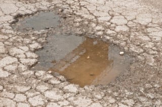 Insidie stradali: l'ipovedente attraversa con la pioggia e cade nella buca? Il risarcimento è a metà